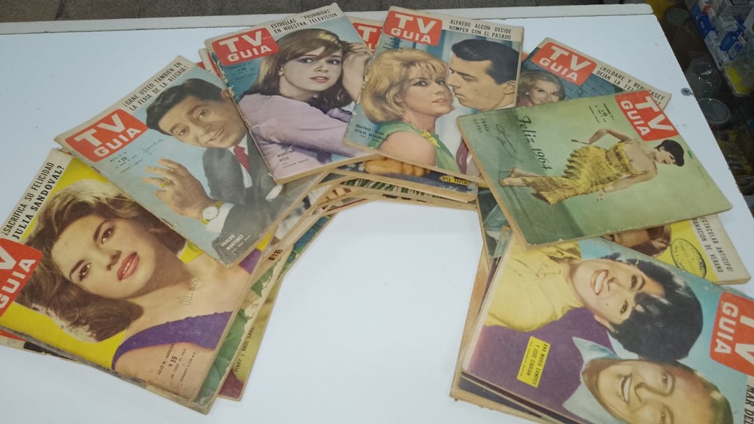 Stack of vintage magazines and archival photographs on a wooden desk