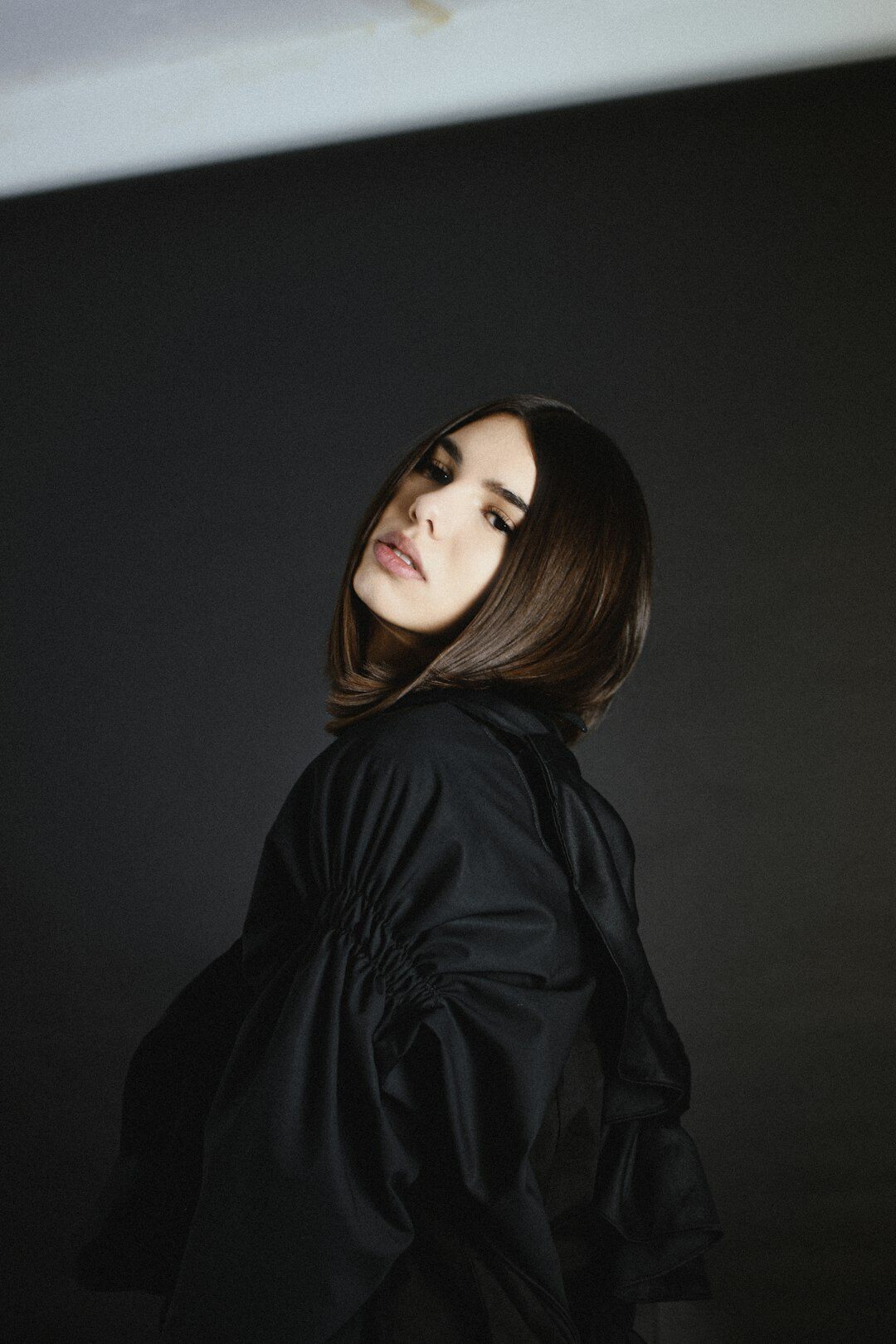 Portrait of a fashion model with sleek hair against a neutral backdrop